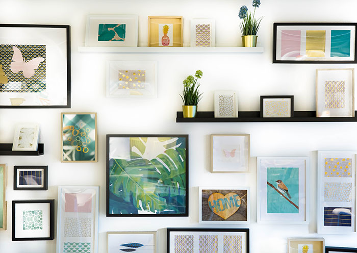 Wall displaying various paintings and photos, perfect for enjoying some “me time.”