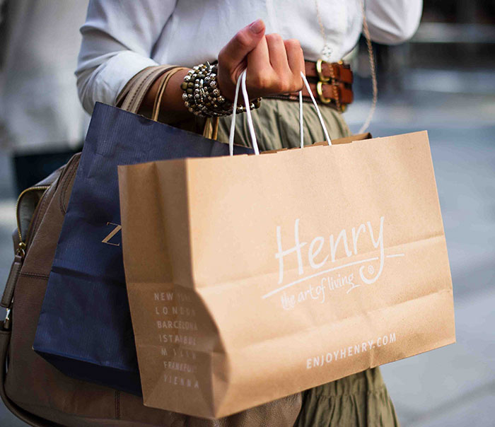 Person enjoying me time shopping with brown and blue bags in hand.