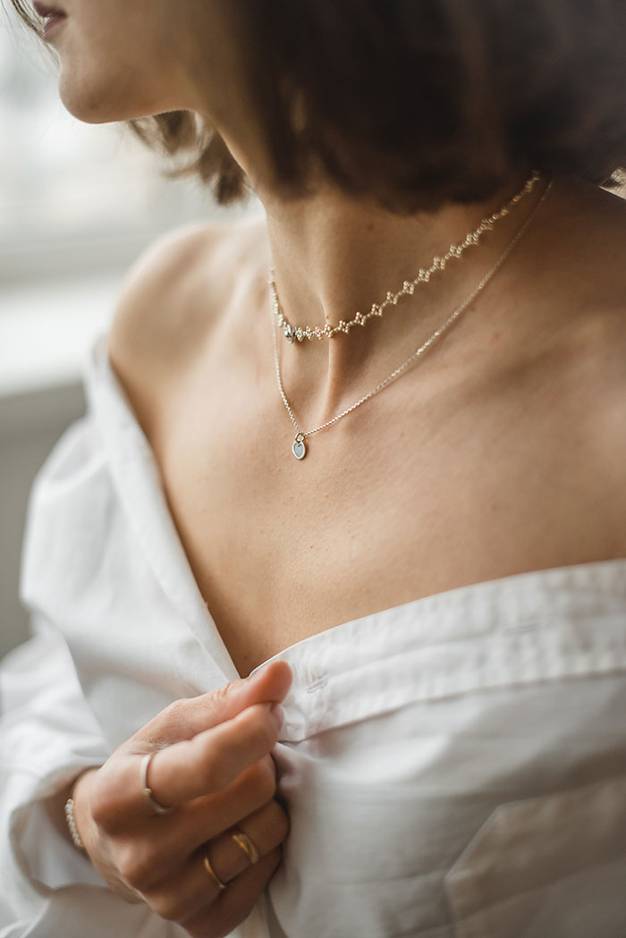 Woman wearing necklace, enjoying some me time in a relaxed setting.