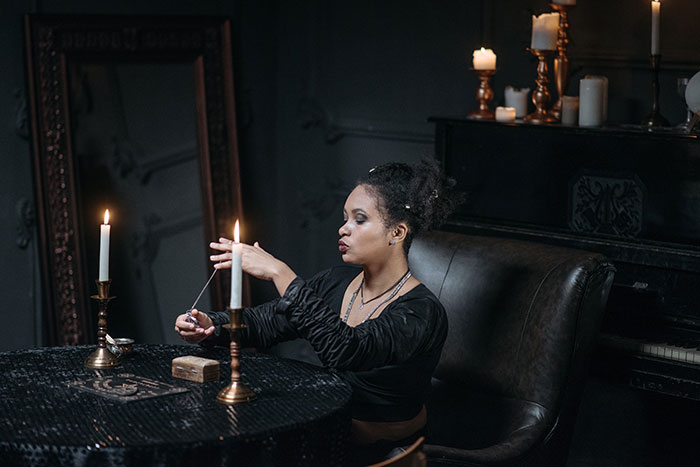Fortune Teller In A Dark Room Lit With Candles 