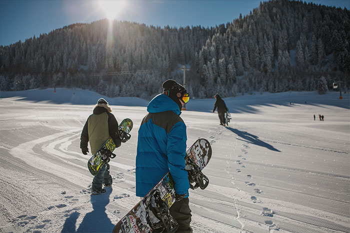 Couple of people with snowboards in snow 