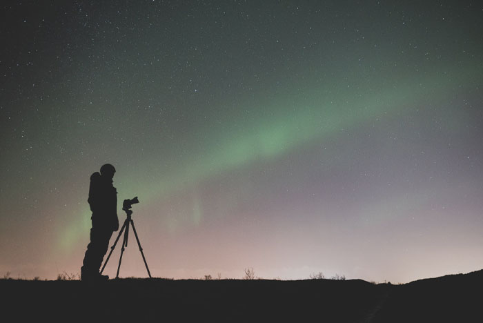 Person spotting northern lights at night 