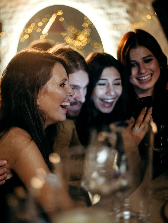 a group of people laughing and watching in a phone