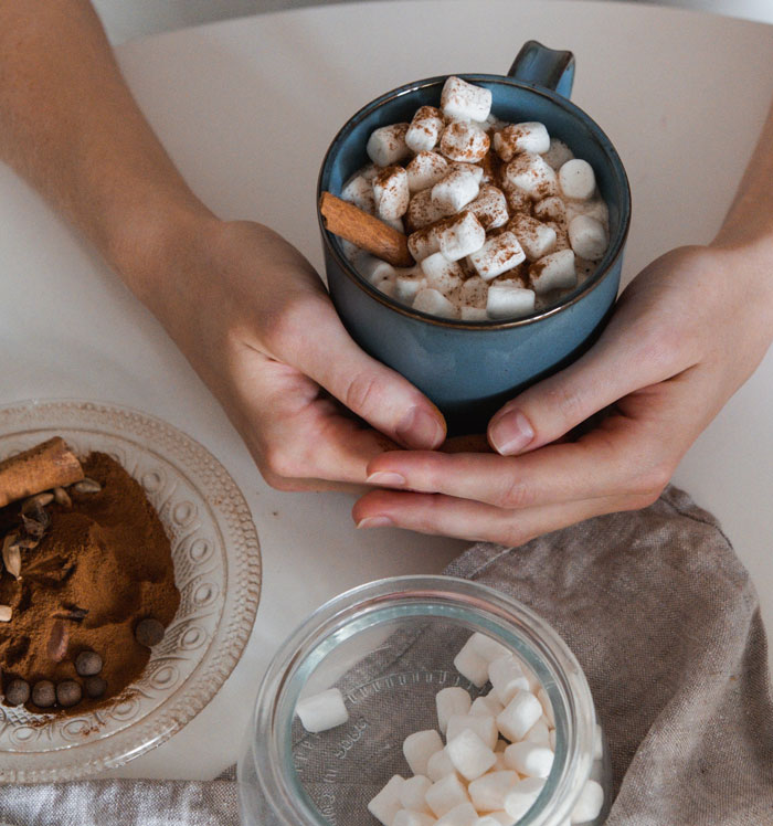 close up view of a cup with cocoa marshmallow and cinnamon