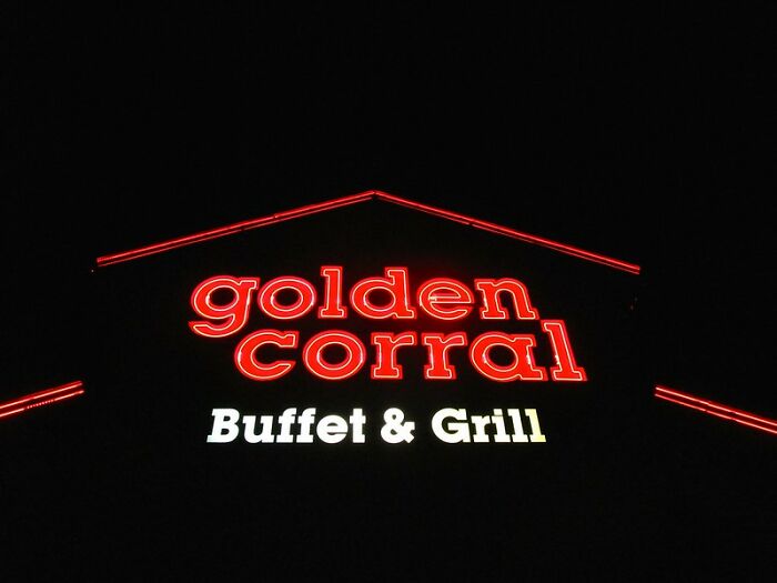 Golden Corral restaurant sign lit up at night, related to never again brand and restaurant experiences.