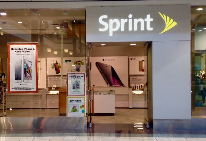 Sprint store front in a mall with promotional signs for iPhone 6 highlighting a common never again brand and store example.