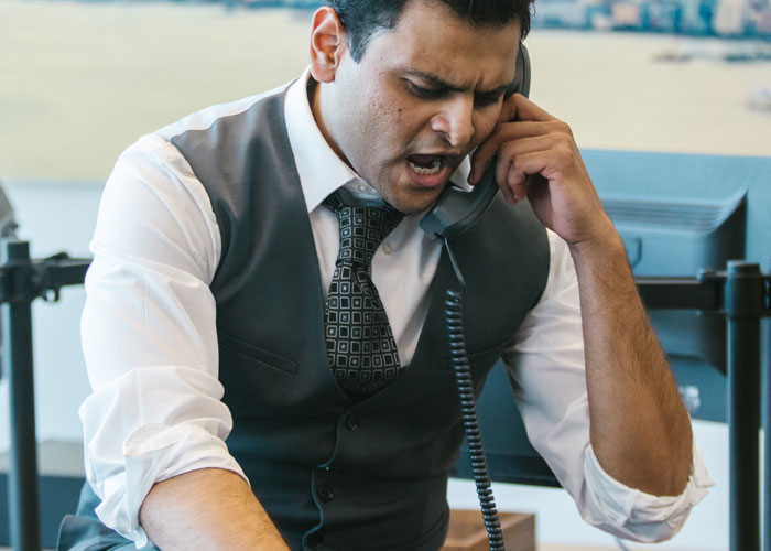 Christian boss upset on the phone about an employee's tattoo idea, dressed in a white shirt and gray vest in an office setting. Christian boss upset on the phone about an employee's tattoo idea, dressed in a white shirt and gray vest in an office setting.