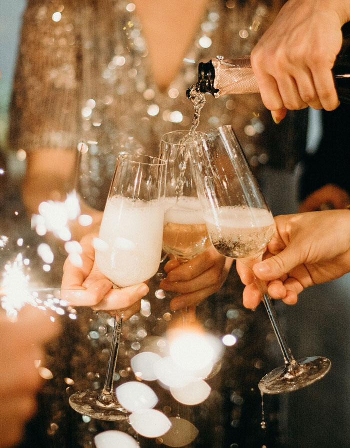 a person pouring champagne into glasses