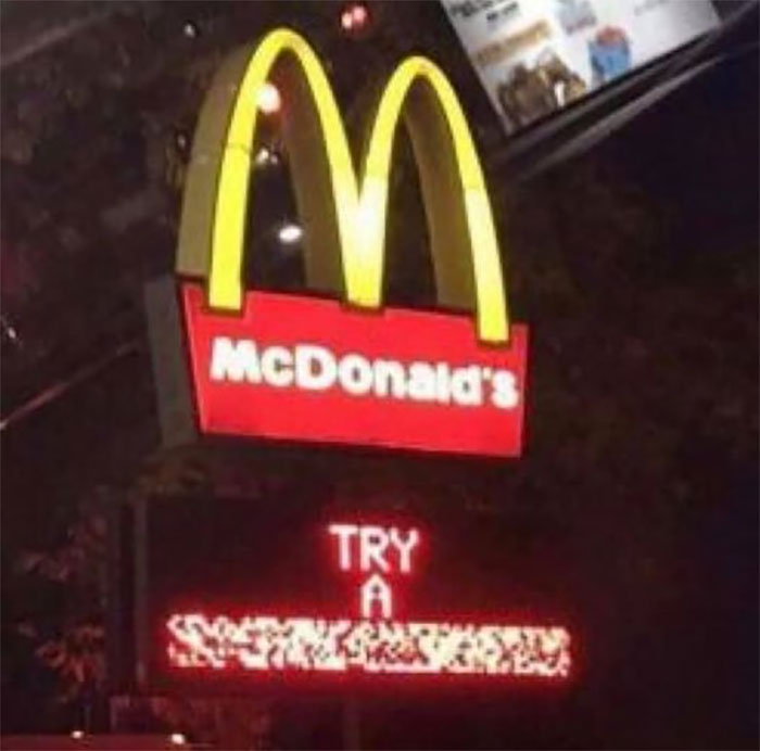 McDonald's sign with distorted, flickering text below, creating a bizarre and cursed image at night.