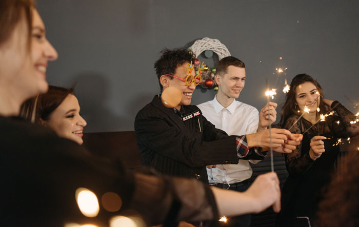a group of people smiling with sparklers in their hands