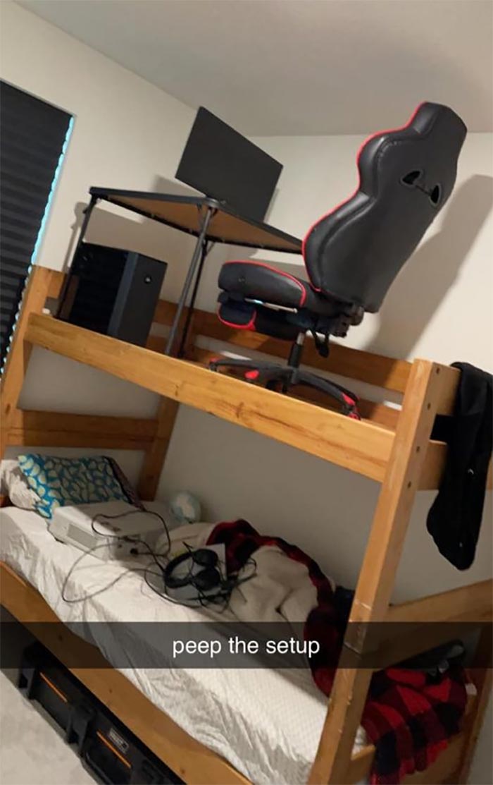 Cursed gaming setup with desk and chair on top bunk, console and headset on lower bed in small room.