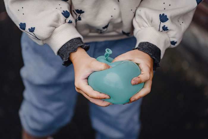 kid trying pop a balloon
