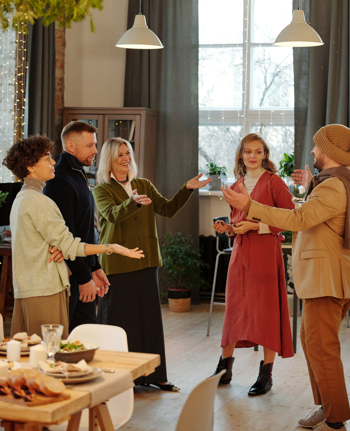 people greeting each other near the table with food