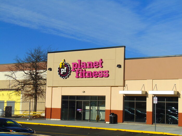 Planet Fitness storefront under a clear blue sky, representing a brand mentioned in never again brand discussions.