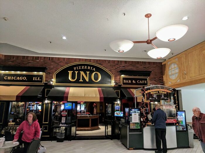 Pizzeria Uno exterior in a mall with customers, representing a notable brand in the never again restaurant discussion.