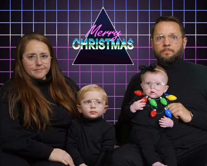 Family poses in funny Christmas card with retro glasses and neon lights background.