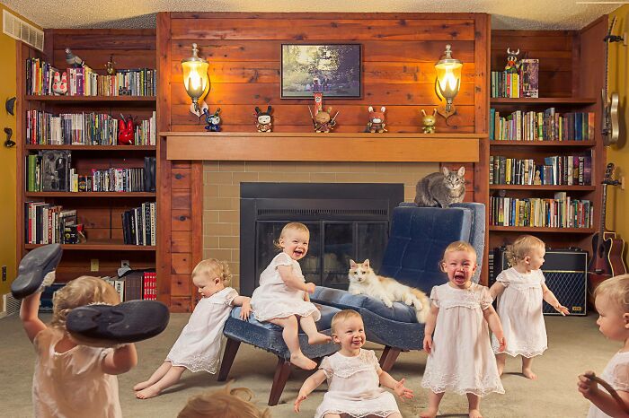Babies in white dresses posing humorously in a cozy living room, perfect for a funny Christmas card.