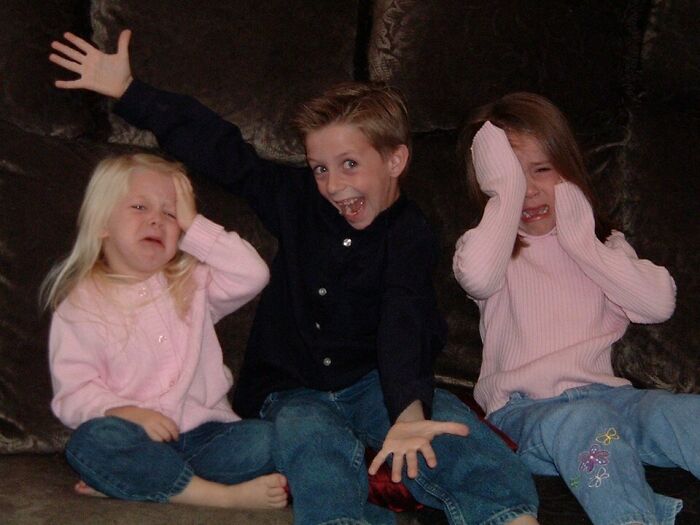 Three kids making funny faces, a humorous capture for a Christmas card.