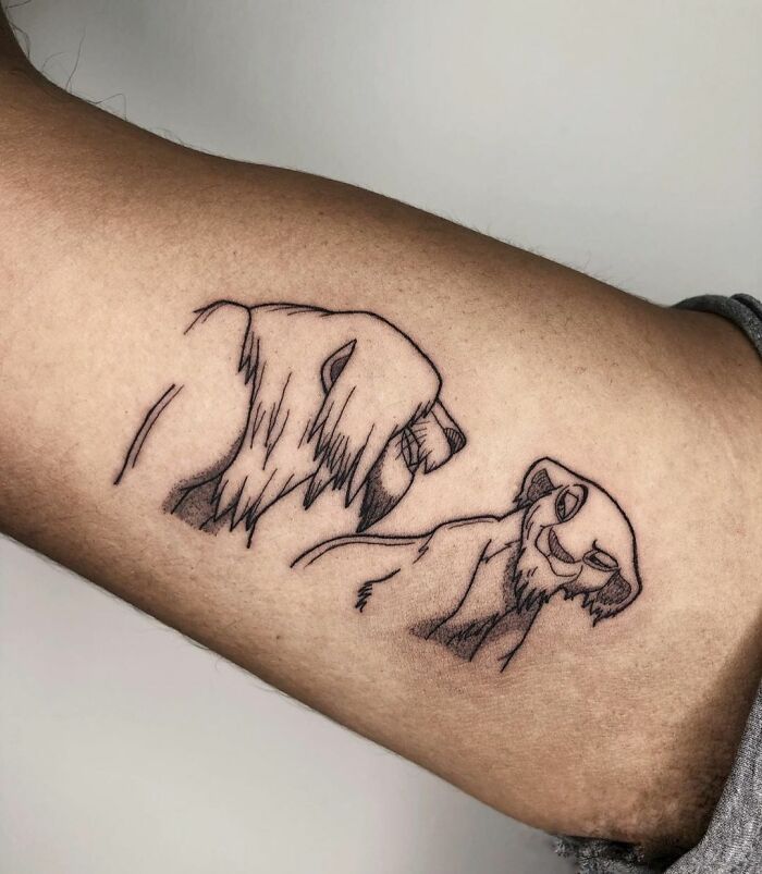 Cartoon tattoo of two sketched lions on an arm, showcasing a nostalgic design.