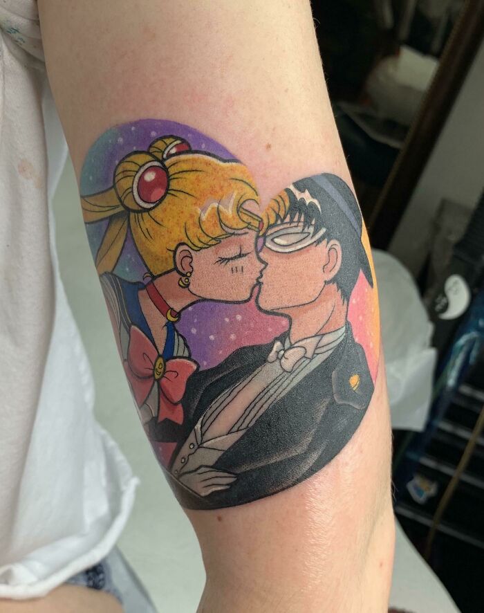 Cartoon tattoo of two characters embracing, capturing the essence of childhood favorites, in vibrant colors on an arm.