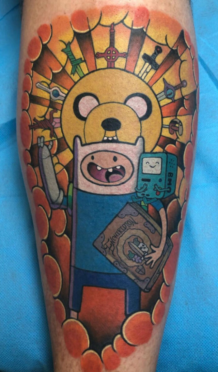Colorful cartoon tattoo featuring iconic Adventure Time characters, capturing nostalgia with vivid details and bold outlines.