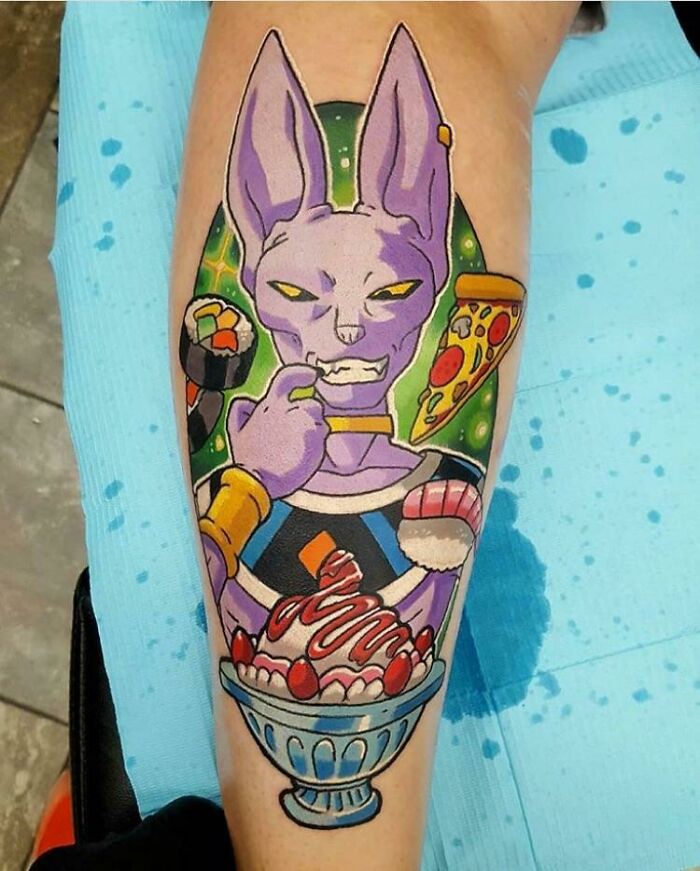 Colorful cartoon tattoo featuring a character Beerus eating pizza and sushi with an ice cream sundae.