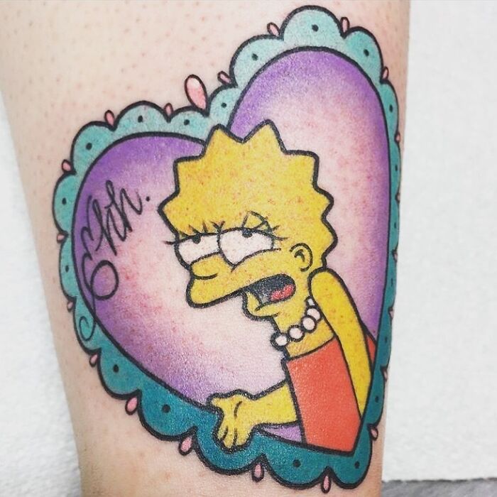 Cartoon tattoo featuring a character Lisa Simpson inside a heart-shaped frame with colorful background.