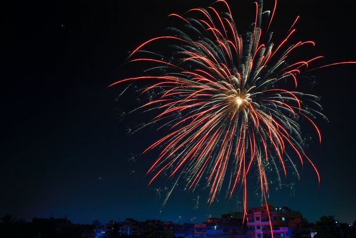 Fireworks lighting up the night sky over a cityscape on New Year’s Eve celebration.