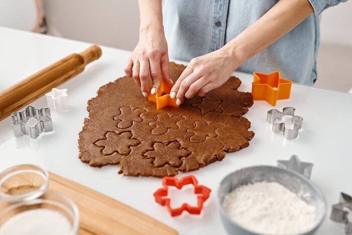 Person cutting dough with star-shaped cookie cutter for New Year’s Eve celebrations.