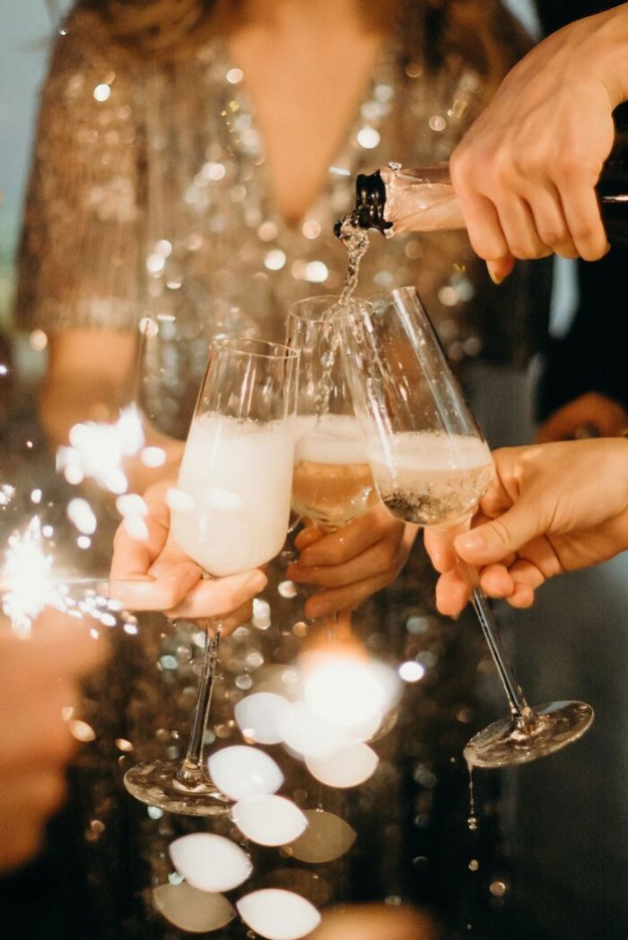 New Year's Eve celebration with clinking champagne glasses and sparklers.