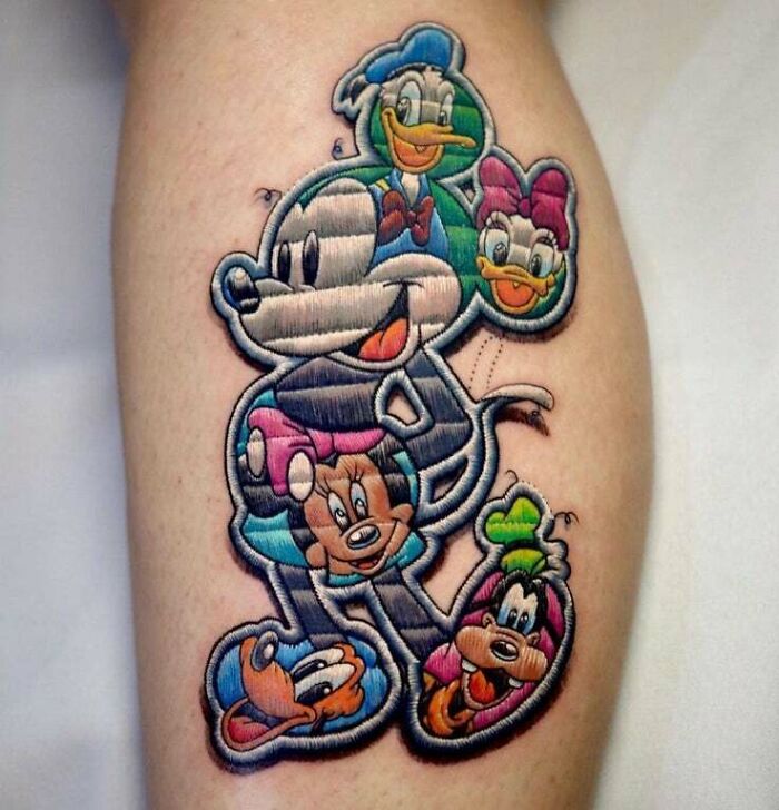 Cartoon tattoo featuring iconic animated characters in colorful patchwork style.