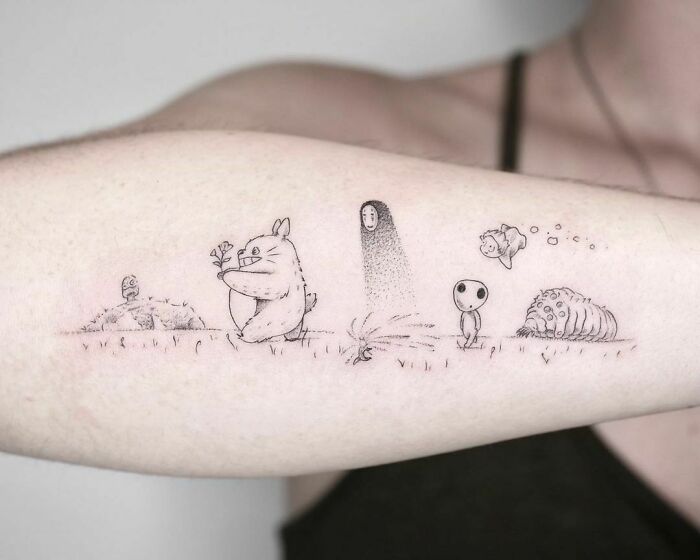 Studio Ghibli cartoon tattoo inspired by favorite animated shows, featuring whimsical creatures on a person's forearm.