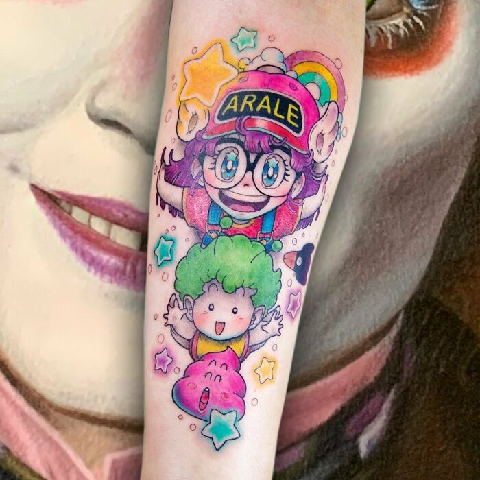 Colorful cartoon tattoo featuring playful characters with stars and a rainbow.