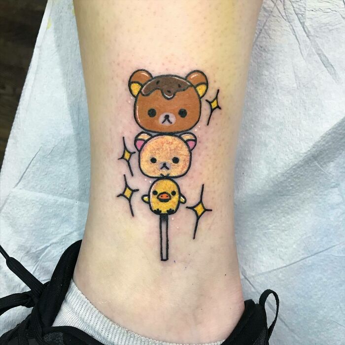 Cartoon tattoo featuring cute bears and a chick from animated shows, resembling a dango on a person's leg.