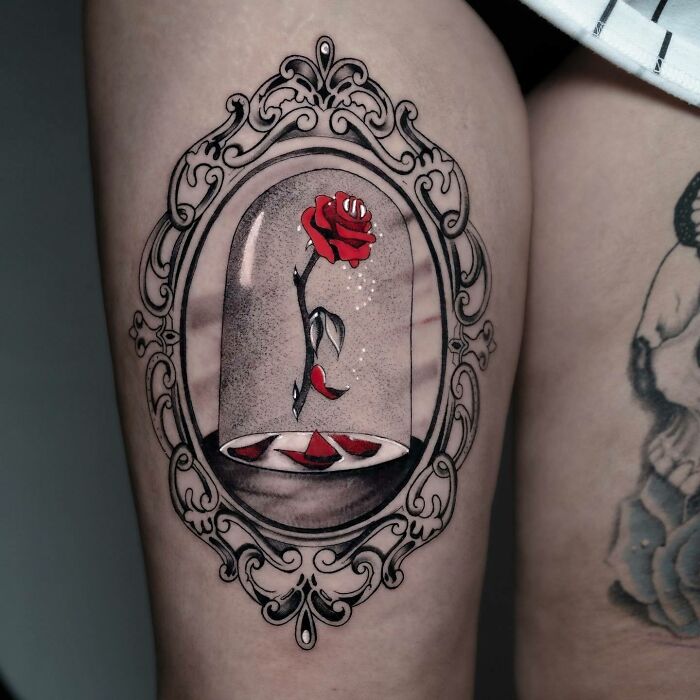 Cartoon tattoo of an enchanted rose in a glass dome, reminiscent of childhood favorites.
