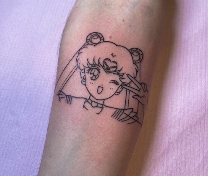 Cartoon tattoo of a character with long hair and a playful pose, evoking childhood favorites.