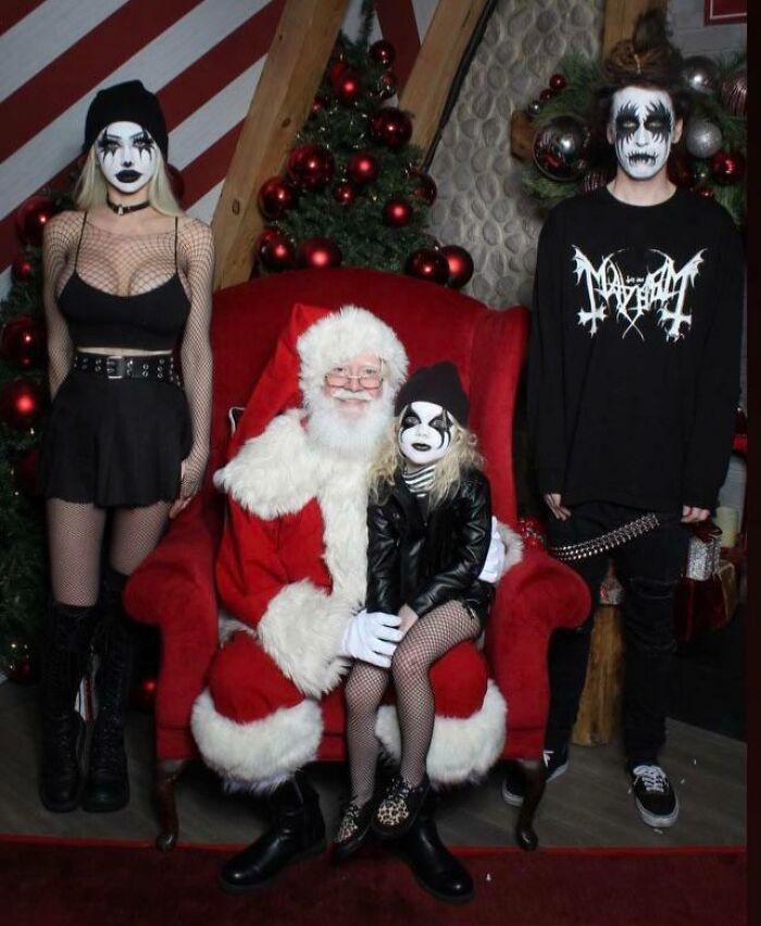 Funny Christmas card with Santa and people in gothic costumes posing humorously.