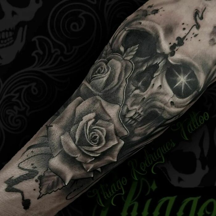 Trippy tattoo featuring a skull with roses on an arm, showcasing intricate black and gray design.