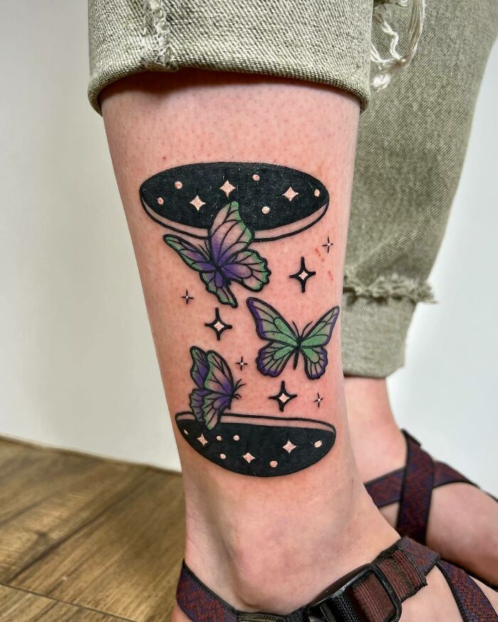 Psychedelic art tattoo of butterflies and stars on a leg.
