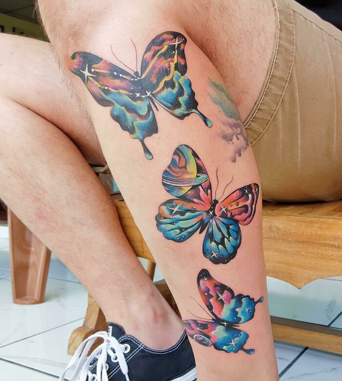 Psychedelic colorful butterfly leg tattoo with stars, showcasing trippy tattoo art.