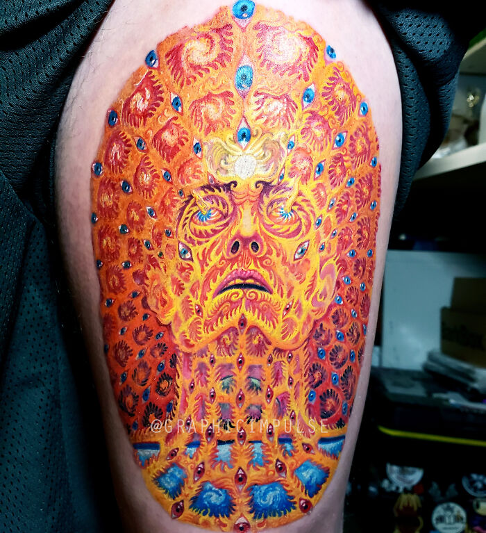 Colorful oversoul leg tattoo with trippy design featuring vibrant orange and blue eye patterns.