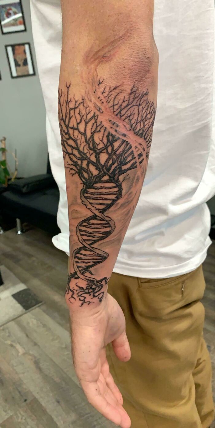 Trippy tattoo of a DNA tree of life on an arm, blending nature and science in artistic design.