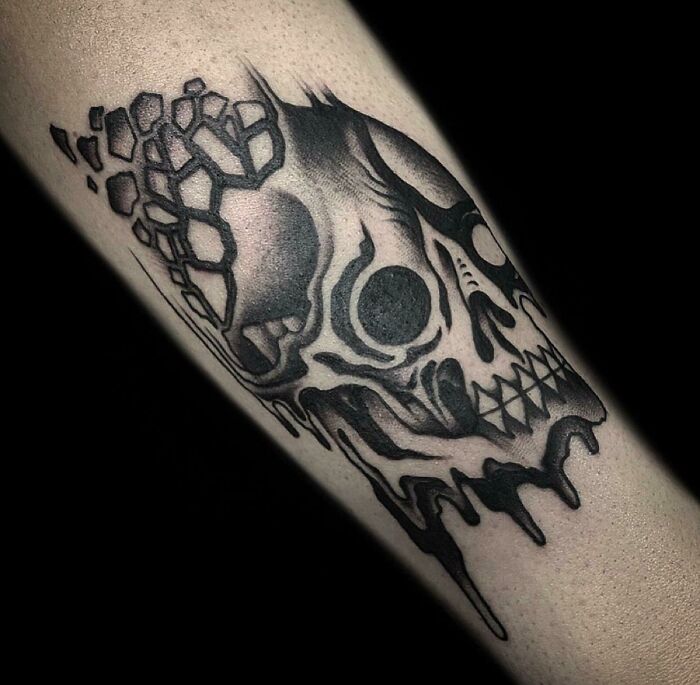 Psychedelic skull tattoo with geometric patterns on arm, featuring dark shading and melting effect.