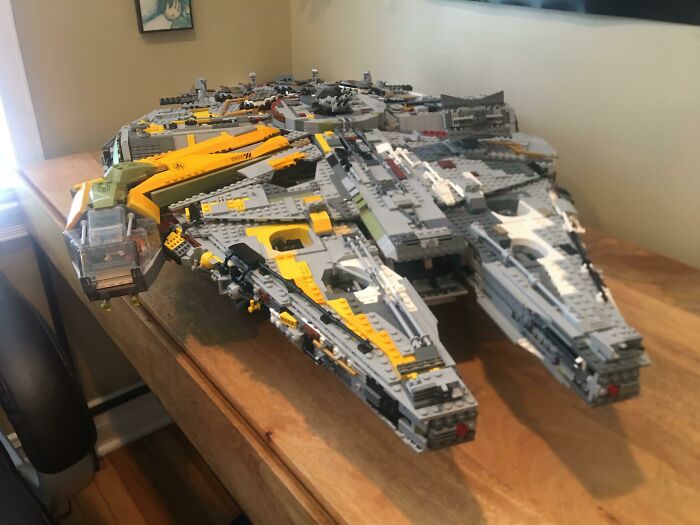 Large detailed LEGO build of a futuristic spaceship displayed on a wooden table, showcasing incredible LEGO art skills.