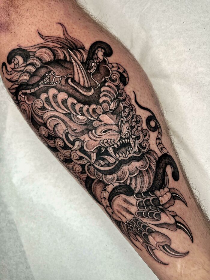 Angry dragon leg tattoo showcasing intricate and trippy design elements.