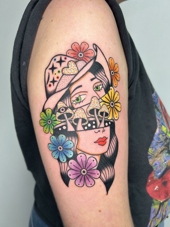 Psychedelic art tattoo featuring a woman's face with mushrooms and colorful flowers.