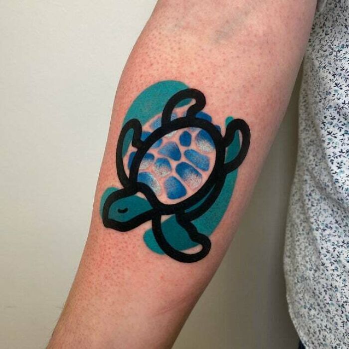 Psychedelic art tattoo of a black-outlined sea turtle with blue patterns on forearm.