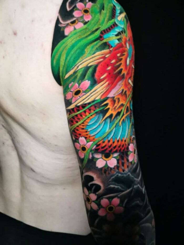 Colorful trippy tattoo with nature and flowers as an arm sleeve design.