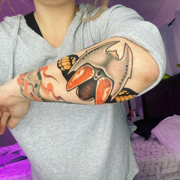 Trippy flying animal tattoo on arm with vibrant colors and bold design.