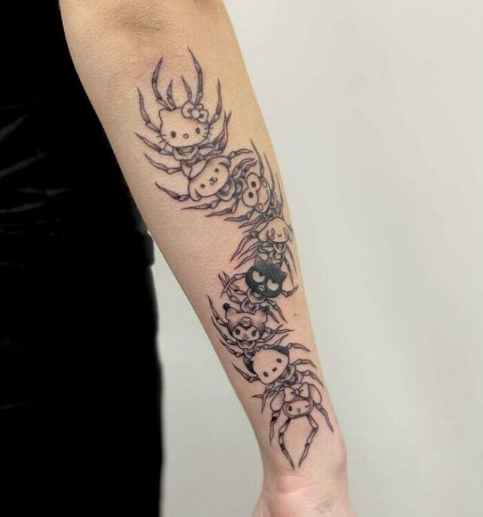 Trippy tattoos featuring cartoon spiders in a creative design on a person's forearm.